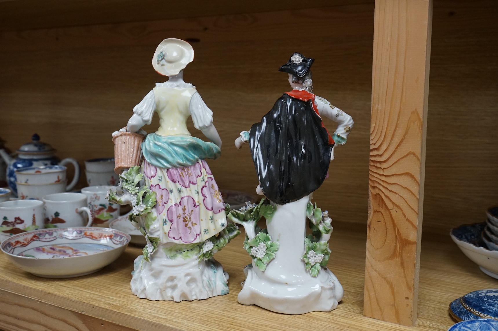 Three late 18th century Derby figures, a similar Derby figure of Summer, c.1810–30 and a Derby style figure of a street vendor, tallest 26cm high